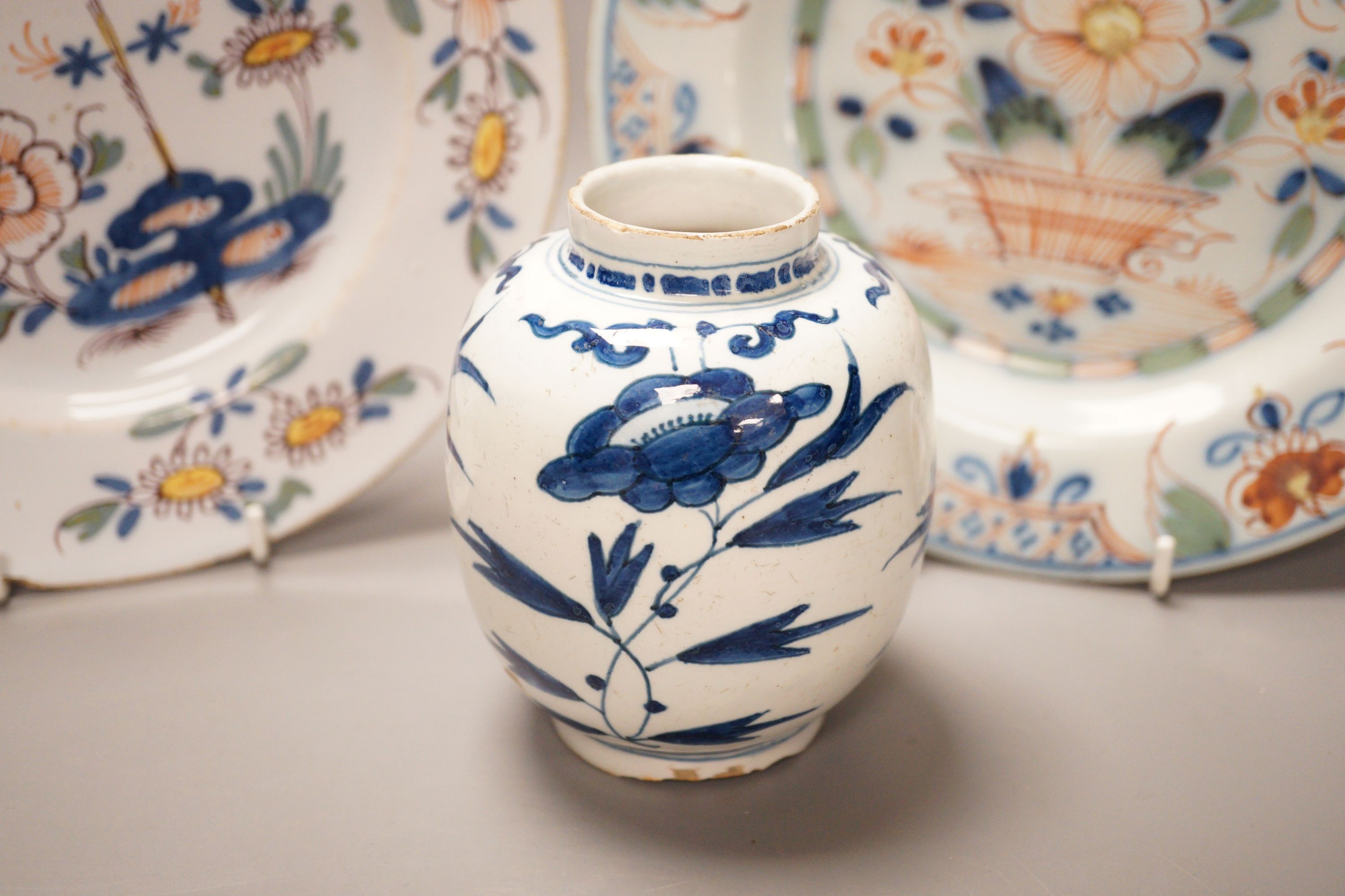 Two 18th century English delftware plates and a 18th century Delft vase, plate diameter 23cm (3)